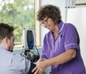 A nurse checking a patient's blood pressure