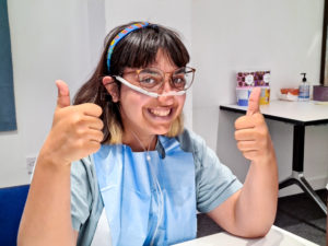 Girl smiling and with thumbs up to camera