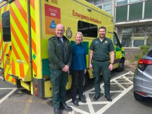 Anne Reid with two paramedics by ambulance