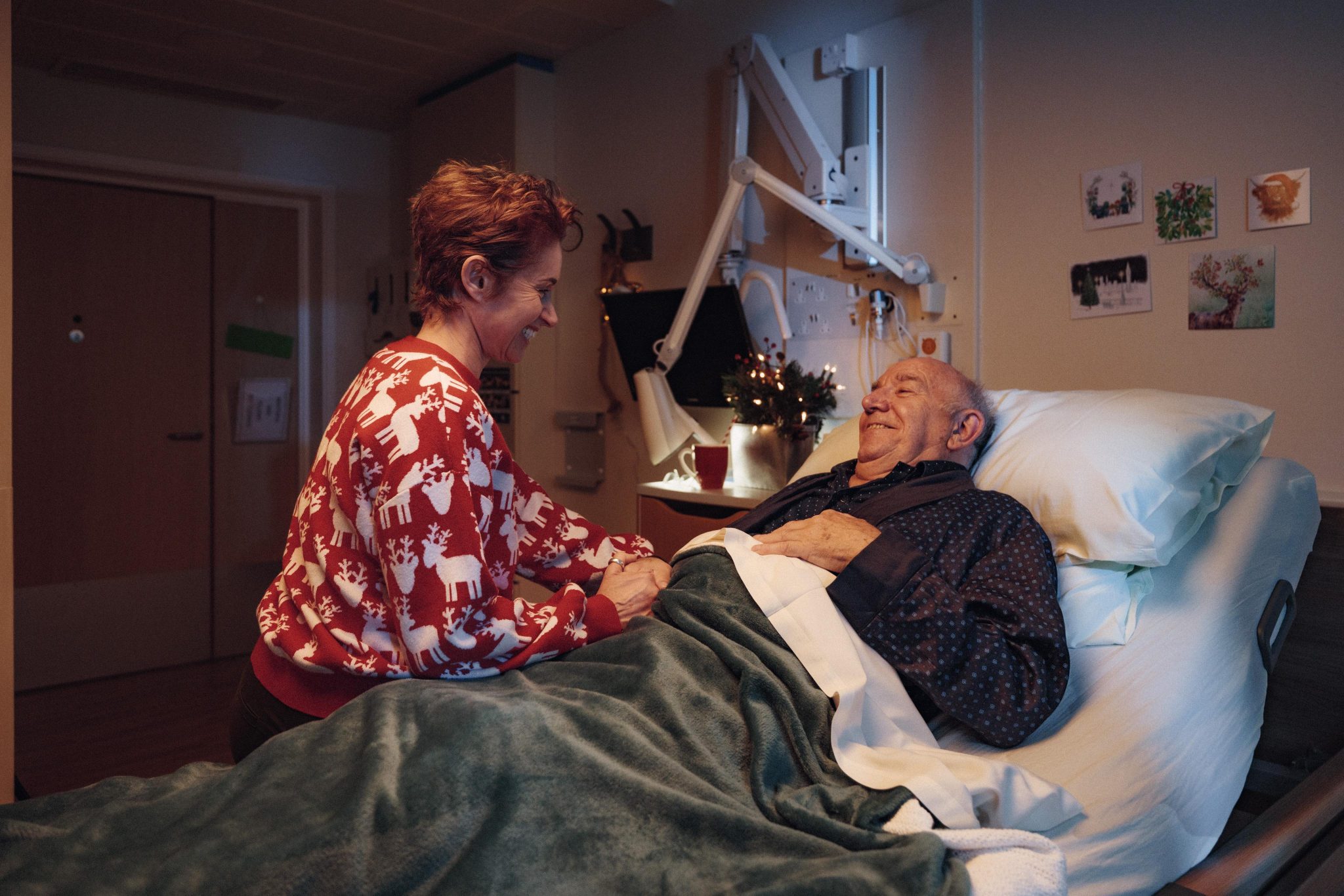 patient in bed on the in patient unit, with his daughter by his side, it's Christmas time