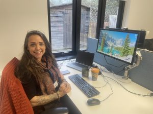 Rebecca smiling at the camera at her desk