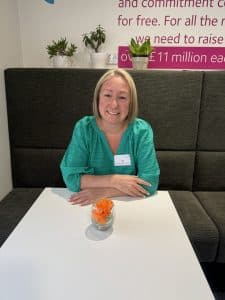 Lady in a green top smiling at the camera